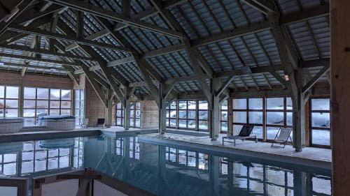 duży basen z krzesłami w budynku w obiekcie Appartement 6/8 pers à 200 m des pistes - piscine w mieście Saint-Sorlin-dʼArves