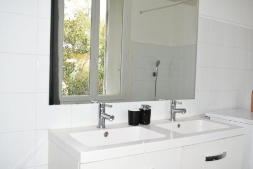 Baño blanco con 2 lavabos y espejo en Appartement Montpellier (proche du centre), en Montpellier
