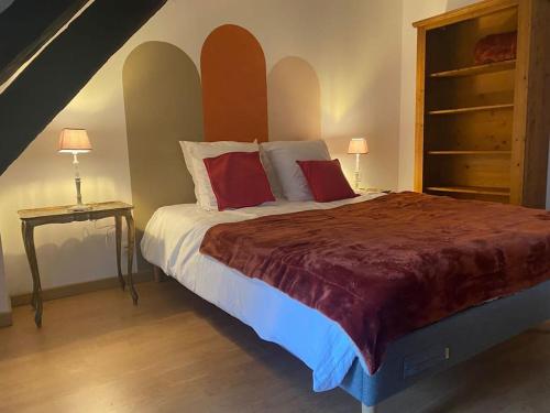 拉昂的住宿－Appartement, cité médiévale，一间卧室配有一张带红色枕头的大床