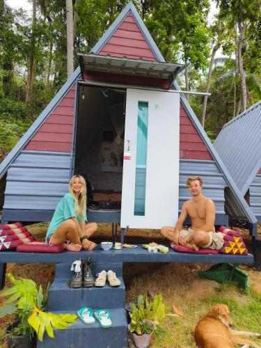 a man and a woman sitting in front of a house at SZ Samui Glamping in Ban Sa Ket