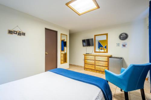 a bedroom with a bed and a blue chair at West Coast Inn's in Boqueron