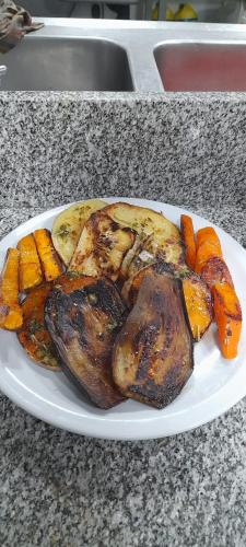a plate of food with chicken and carrots on a counter at Rancho Grande Hostel in El Chalten