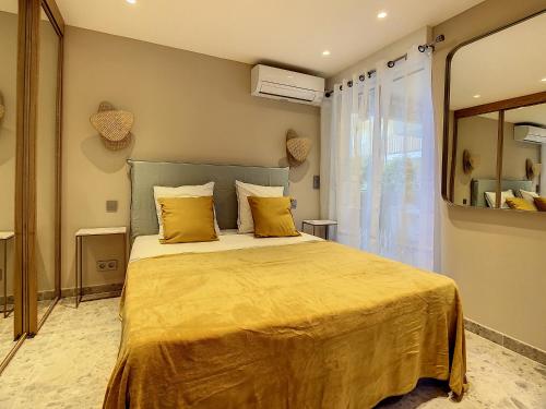 une chambre avec un grand lit avec des oreillers jaunes dans l'établissement Paradise- Saint-Tropez- Résidence Piscine, à Saint-Tropez