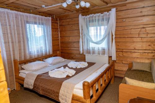 um quarto com uma cama num chalé de madeira em КРЕМІНЬ em Dragobrat