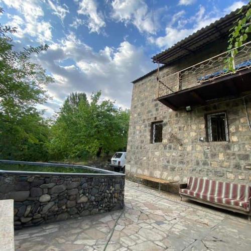 a building with a bench next to a stone wall at Rent Hause in Vedi