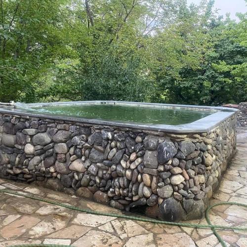 a rock retaining wall with a pool of water at Rent Hause in Vedi