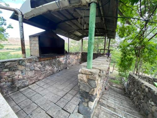 a building with a stone wall and a stone patio at Rent Hause in Vedi