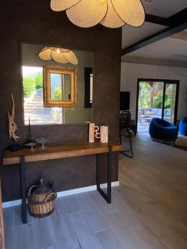 - un salon avec une table et un miroir dans l'établissement Un paradis avec piscine au cœur du village, à Cassis