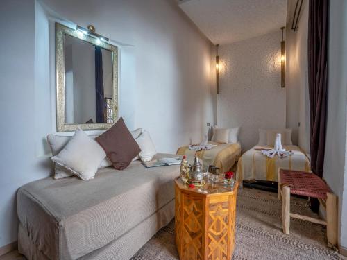 a hotel room with a bed and a mirror at Riad Maialou & SPA in Marrakech