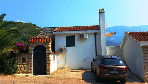 a car parked in front of a white house at Klaris Guest house in Budva