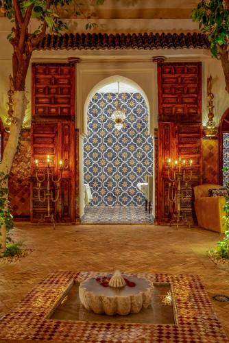 a living room with a table in the middle of a room at Riad Maialou & SPA in Marrakech