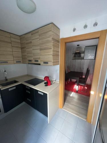 a kitchen with wooden cabinets and a red chair at Piso con jardín en Liencres in Liencres