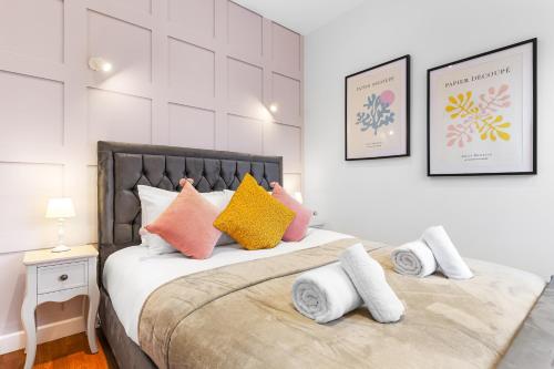 um quarto com uma cama com almofadas coloridas em Modern One Bedroom Flat - Near Heathrow, Windsor Castle, Thorpe Park - Staines London TW18 em Londres