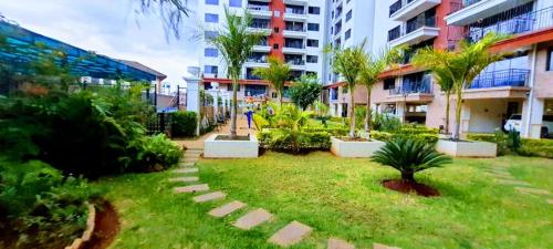 een tuin met palmbomen in het midden van een gebouw bij the perfect affordable apartments in Nairobi