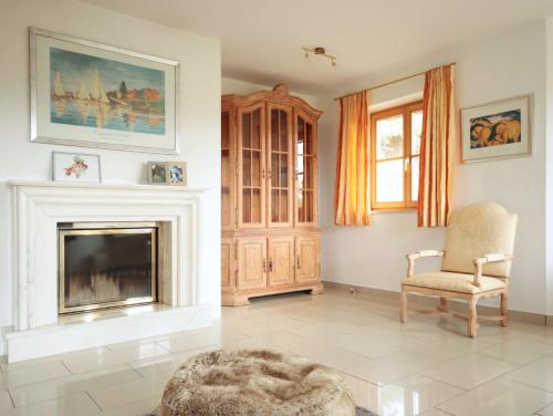 a living room with a fireplace and a chair at Guade Stub'n ALBERT-SEPPI in Polling