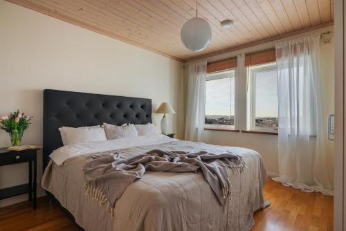 1 dormitorio con 1 cama grande y 2 ventanas en Vetteberget Huset en Fjällbacka