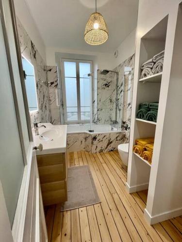 une salle de bain avec un lavabo, des toilettes et une baignoire dans l'établissement Maison Meulière avec jardin, à Épernay