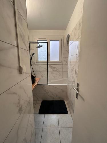 ein Bad mit einer Dusche und einem Fenster in der Unterkunft LA BELLE ESCALE in Belfort