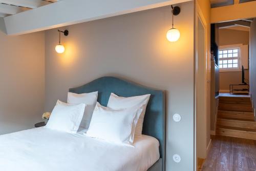 a bedroom with a bed with white pillows at Aparthotel Largo da Oliveira in Guimarães