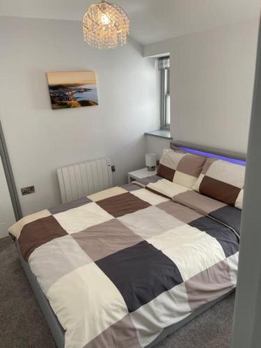 une chambre avec deux lits et un lustre dans l'établissement Maisonette flat Aberystwyth, à Aberystwyth