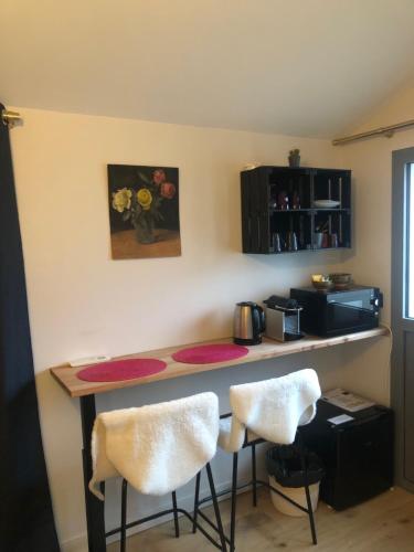 a kitchen with a counter and two stools at Chambre indépendante Charbonnières Les Bains in Charbonnières-les-Bains