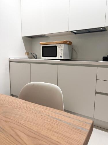 a kitchen with a table and a microwave on a counter at GINNY HOUSE VENEZIA in Dolo