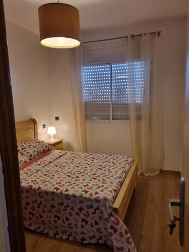 a small bedroom with a bed and a window at Appartement propre et soigné in Salé