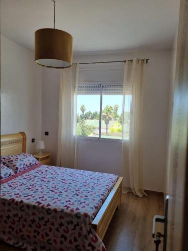 a bedroom with a bed and a window at Appartement propre et soigné in Sale