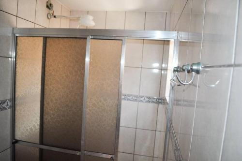um chuveiro com uma porta de vidro na casa de banho em Casa 54 em São Sebastião