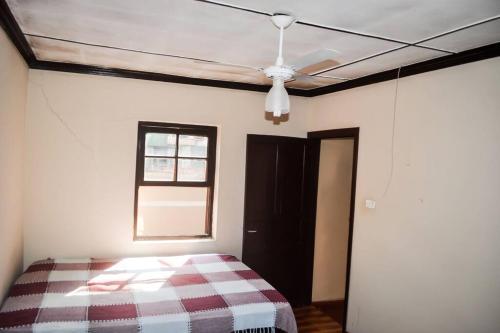 um quarto com uma cama e uma ventoinha de tecto em Casa 54 em São Sebastião