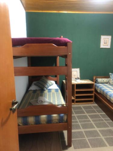 two bunk beds in a room with green walls at Casa Aconchegante na Montanha in Campos do Jordão