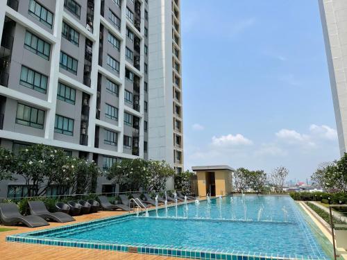 a swimming pool in front of a tall building at 2BR Apartment in Bangkok