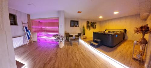 a large living room with a tv and purple lighting at Apartamenty Wakacyjne Historie in Międzylesie