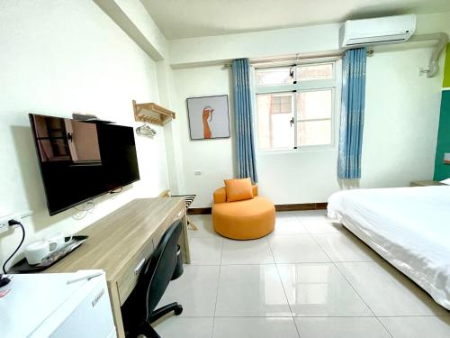 - une chambre avec un lit, un bureau et une télévision dans l'établissement Banshan Yunxiu Homestay, à Jinning