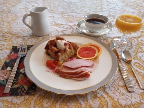 夏洛特顿The Dawson House Bed & Breakfast的一盘有肉和橙子的食物，还有一杯咖啡