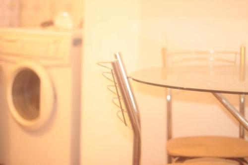 a table and chair in a kitchen with a refrigerator at Apartamento completo temporada privativo no centro in Porto Alegre