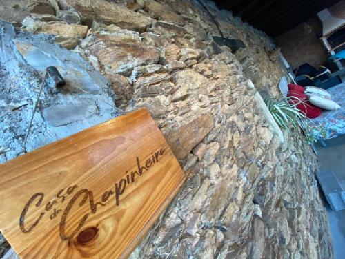 a wooden sign on a stone wall at Casa da Chapinheira in São Pedro de Alva