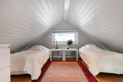 2 camas num quarto no sótão com uma janela em Vetteberget Anexet em Fjällbacka
