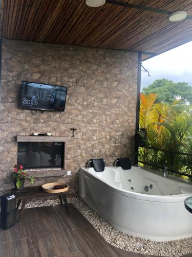 a large bathroom with a large tub and a tv at Verdes Hábitat Glamping in Palestina