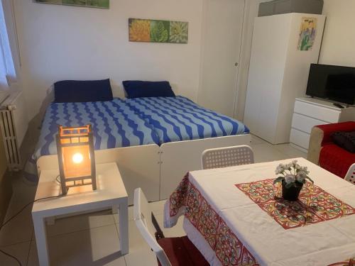 Habitación pequeña con cama y mesa con lámpara. en OnlyRoomsRho, en Rho