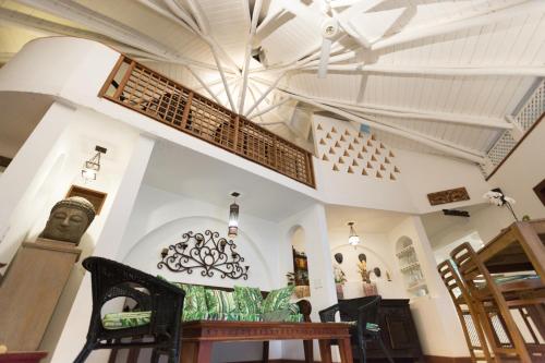 a dining room with a table and a chandelier at Hotel Casa Coson in Las Terrenas