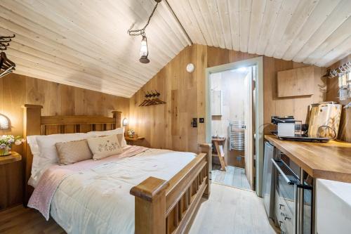 a bedroom with a bed in a room with wooden walls at The Treehouse at Salcombe Farm in Salcombe