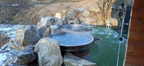 a hot tub in the middle of some rocks at Penzión Zbojnícky Halaš in Tisovec