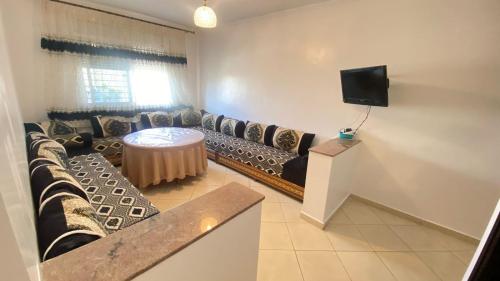 a living room with a couch and a tv at Nador Holidays in Nador