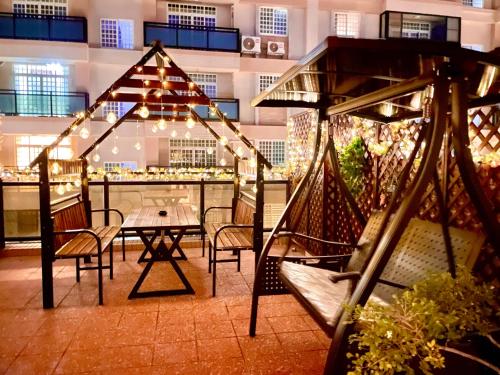 a patio with a table and chairs and lights at Banshan Yunxiu Homestay in Jinning