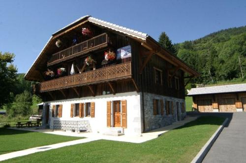a large house with flowers on the top of it at La Ferme de Sous-Lachat in Samoëns