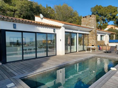 une maison avec une piscine et une terrasse dans l'établissement Magnifique villa avec piscine, vue mer, à La Croix-Valmer