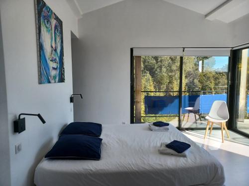sypialnia z łóżkiem i dużym oknem w obiekcie Magnifique villa avec piscine, vue mer w mieście La Croix-Valmer