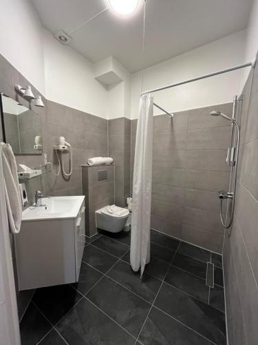 a bathroom with a shower and a toilet and a sink at Hotel Skandia in Helsingør