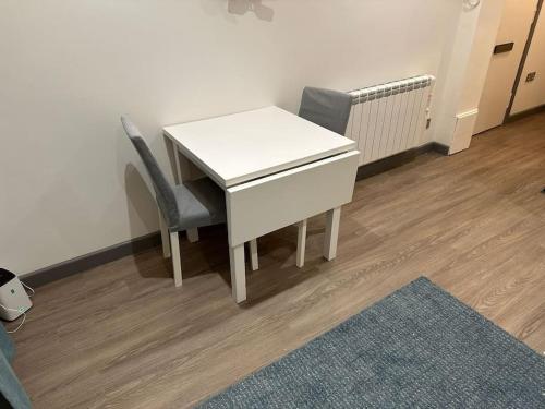a white desk and two chairs in a room at Riverview Apartment, Inverness in Inverness